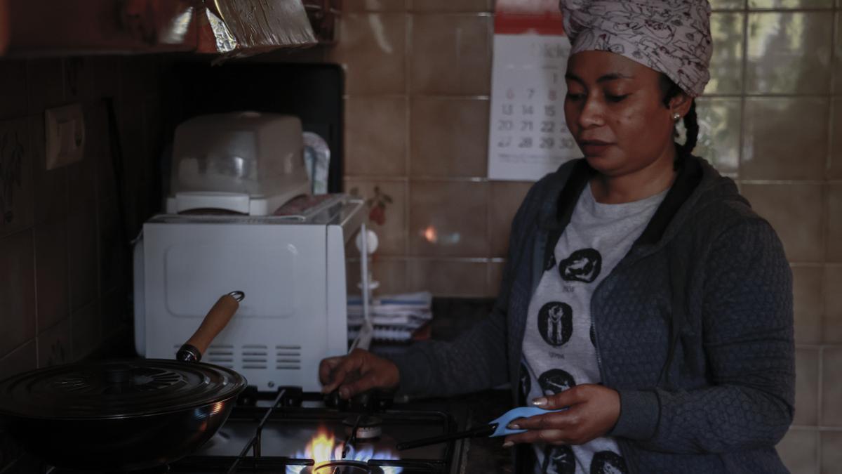 Olga encendiendo su cocina de gas en su piso del barrio valenciano de la Fuensanta