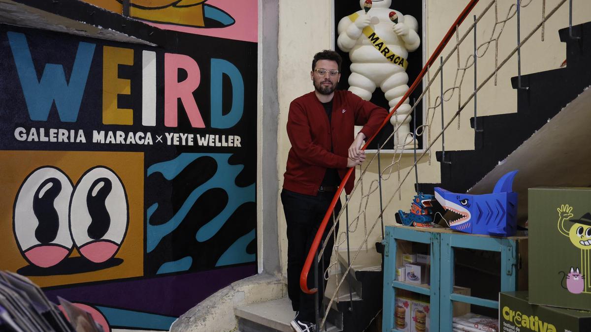 Raúl Bermúdez en Galaría Maraca junto a un mural de Yeye Weller, que participó en 2024 en el Festival Creativa.
