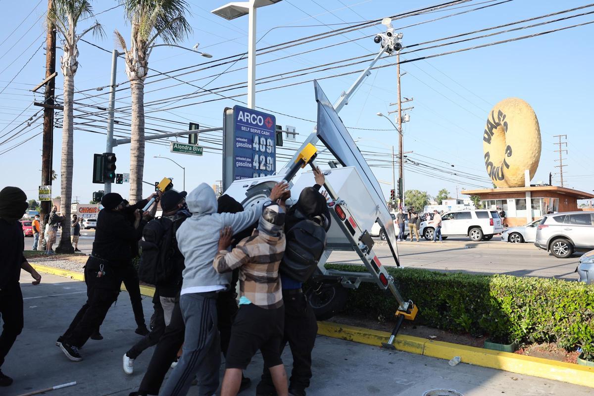 Manifestantes destrozan un poste de vigilancia policial durante las protestas por las detenciones en Paramount.