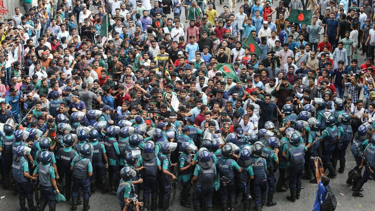 Estudiantes y aspirantes a un puesto de trabajo portando banderas nacionales participan en una marcha de protesta en Dhaka, Bangladesh.