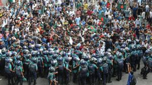 Estudiantes y aspirantes a un puesto de trabajo portando banderas nacionales participan en una marcha de protesta en Dhaka, Bangladesh