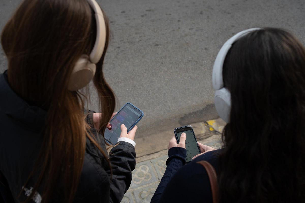 Dos personas utilizan el teléfono móvil.