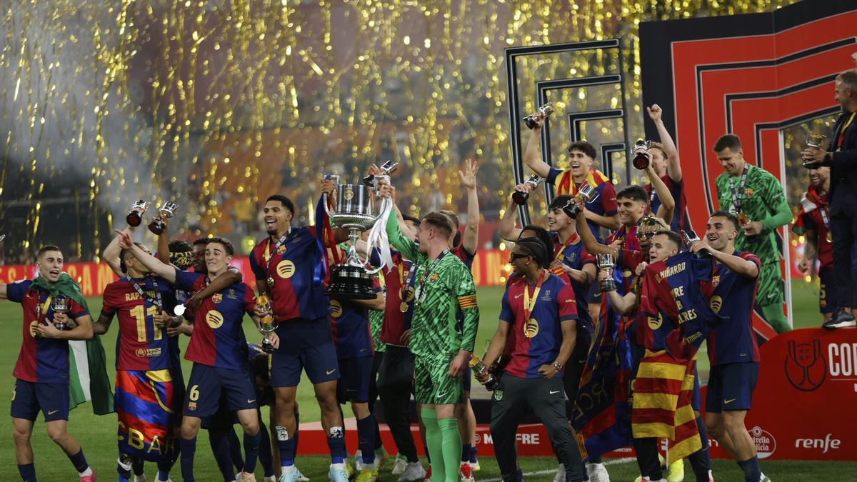 Barcelona's Ronald Araujo, left, and Barcelona's goalkeeper Marc-Andre ter Stegen lift the trophy after winning the Spanish Copa del Rey final soccer match between Barcelona and Real Madrid at Estadio de La Cartuja stadium in Seville, Spain, Sunday, April 27, 2025. (AP Photo/Joan Monfort)