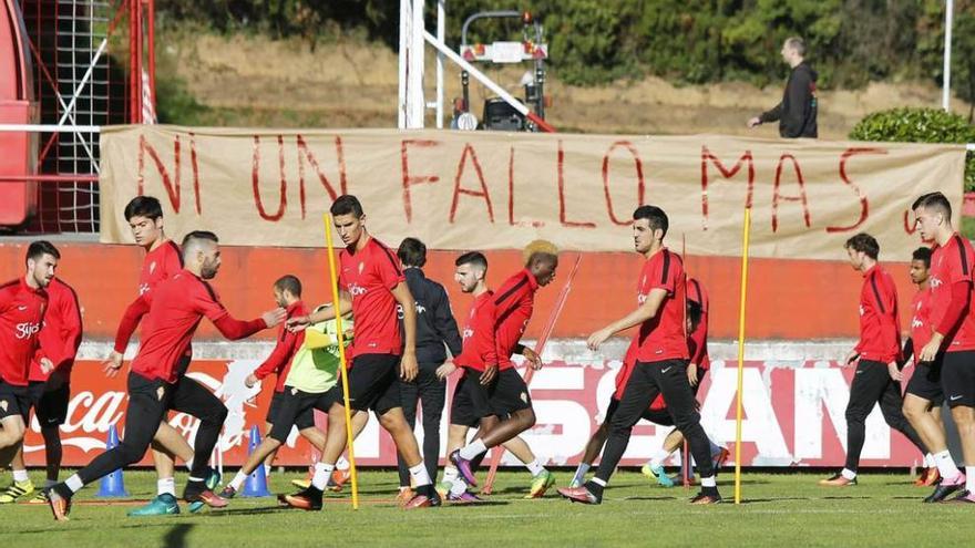 Los jugadores del Sporting trabajan ante la pancarta que fue retirada por Ultra Boys.
