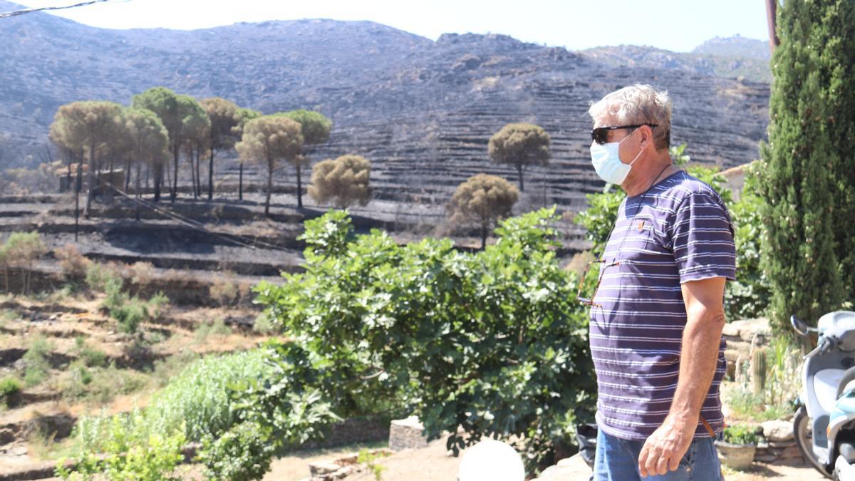 Un veí de la Vall de Santa Creu amb les muntanyes cremades de fons després de l&#039;incendi entre Llançà i el Port de la Selva