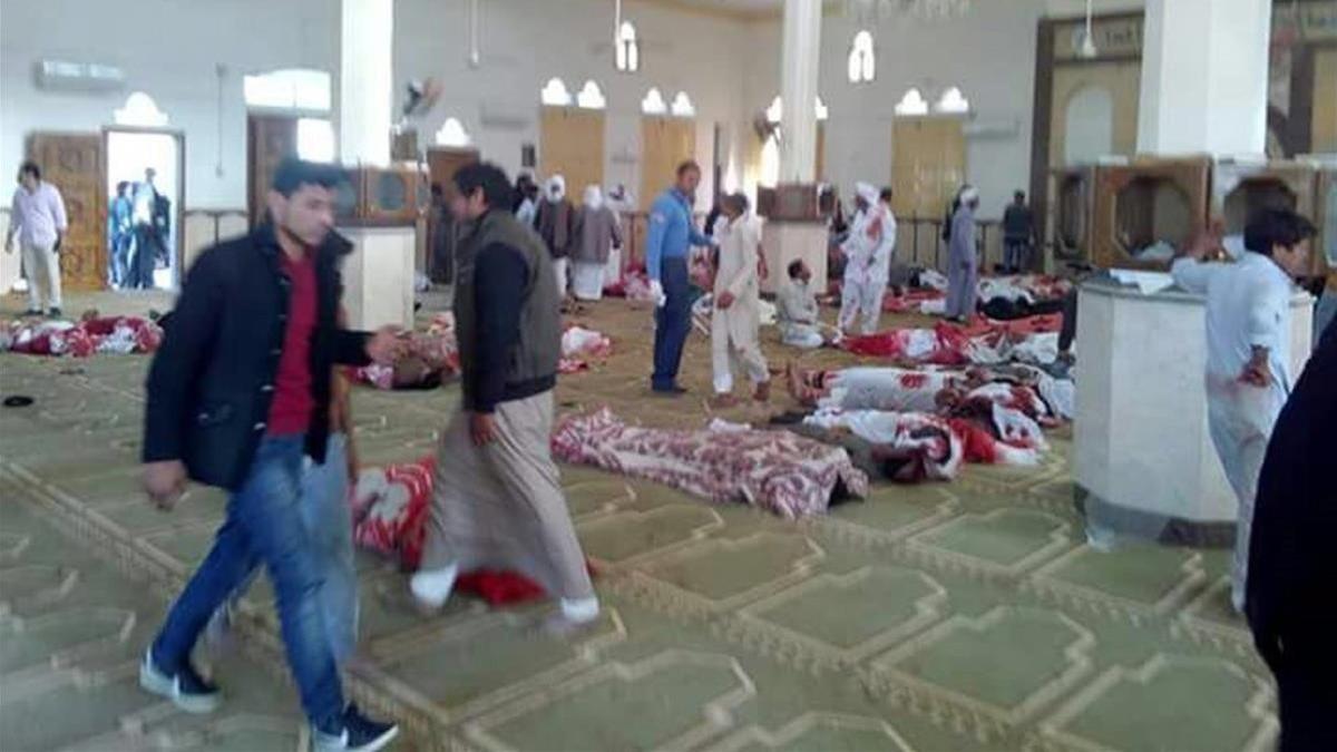 Varias personas permanecen junto a cuerpos sin vida en el interior de la mezquita atacada, en Al Arish, en el norte del Sinaí, el 24 de noviembre.