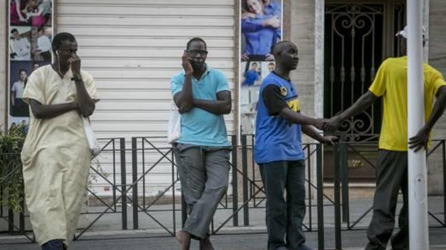 Inmigrantes hablando por teléfono móvil en las calles ilicitanas.