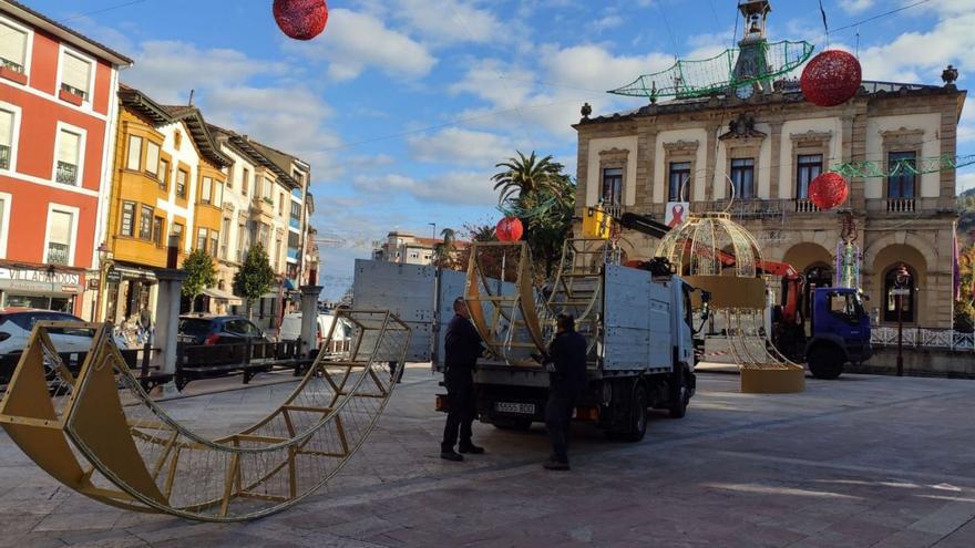 Operarios instalando ayer las últimas piezas, como el arco de la plaza del Ayuntamiento y las hojas de acebo. | Alicia García-Ovies