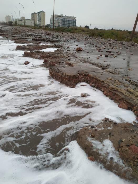 Agua y arena invaden el paseo del Puig.