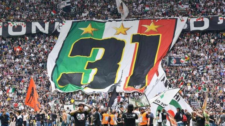 La afición de la Juventus ondea una bandera gigante simulando el &quot;scudetto&quot; con el número 31. // Di Marco