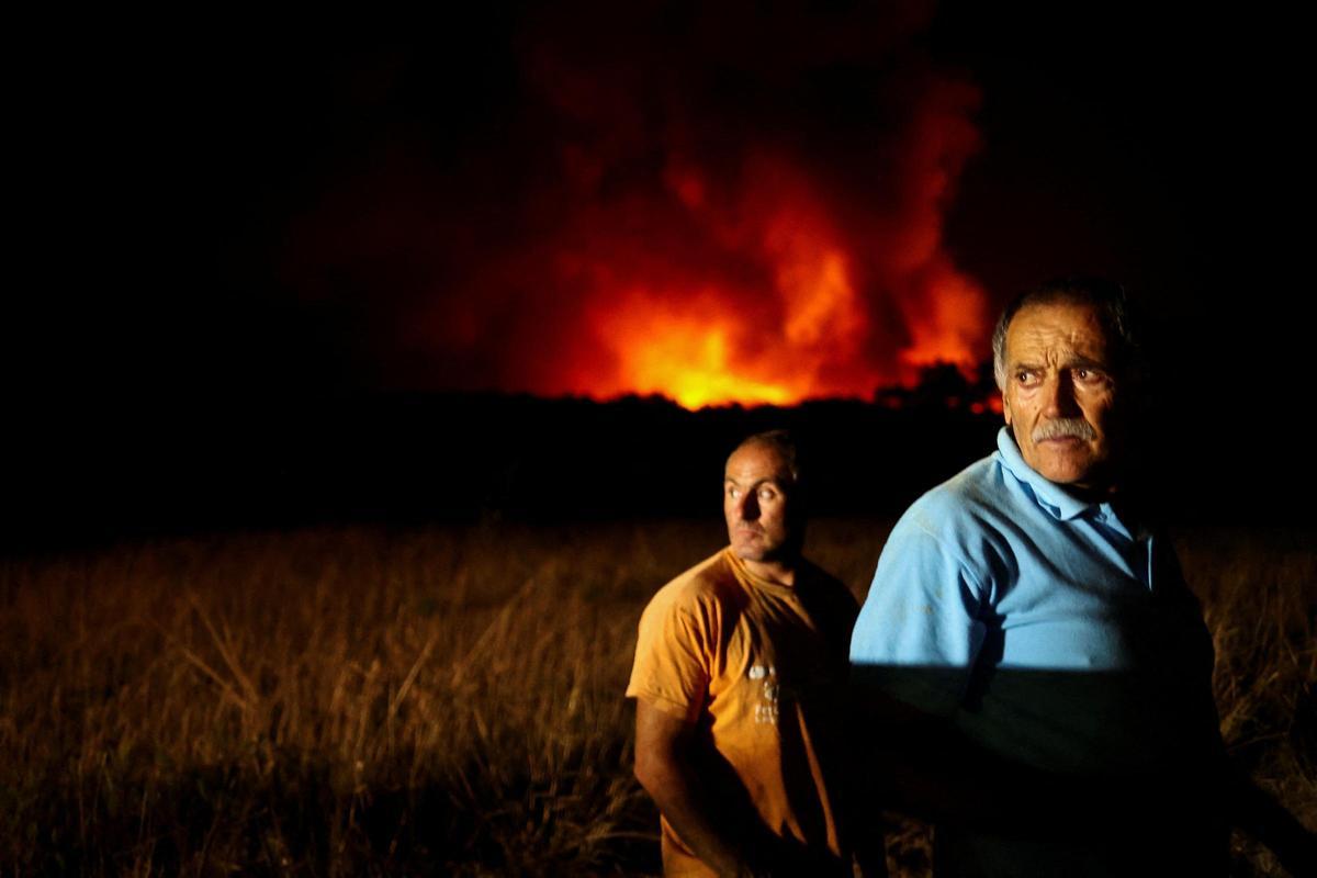 Dos personas ven un incendio forestal en Aljezur, Portugal