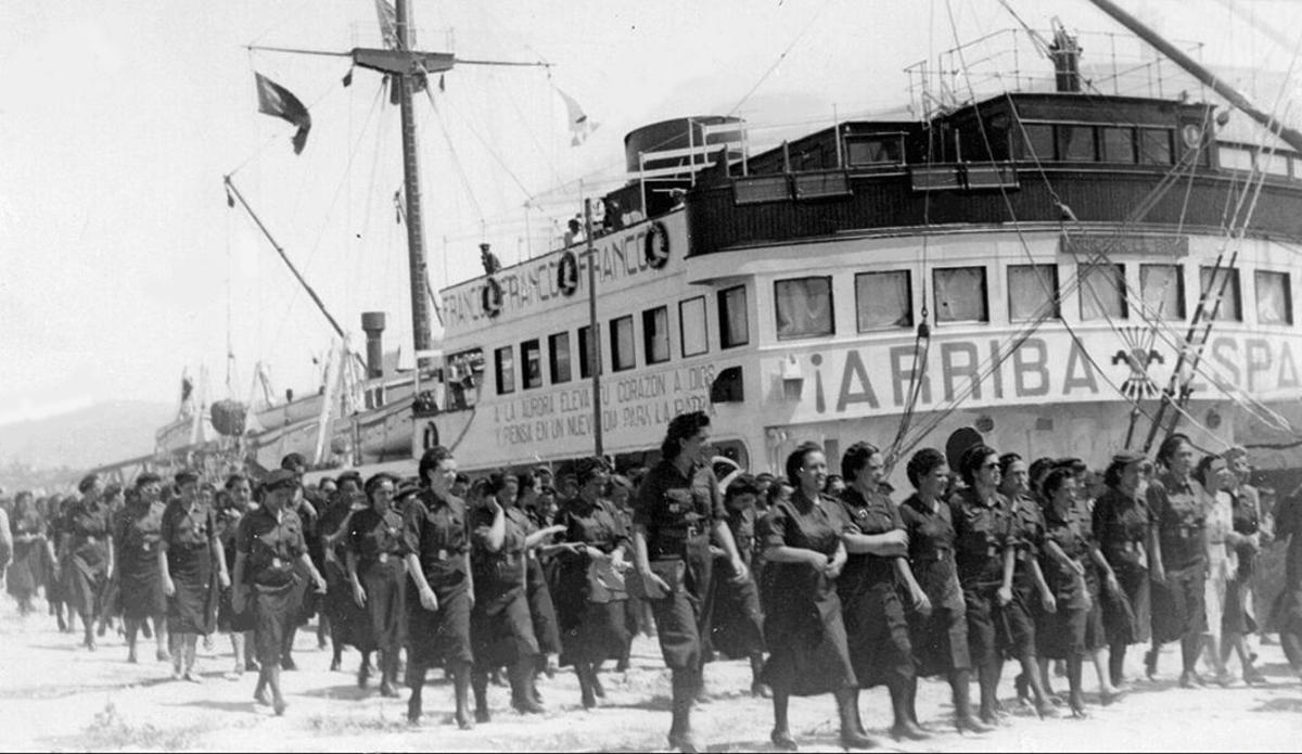 Miembros de la Sección Femenina local, desfilando ante el «Ciudad de Alicante» durante su visita a Vigo.