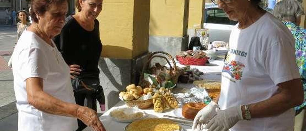 Clientas comprando en el mercadillo solidario de Colunga.