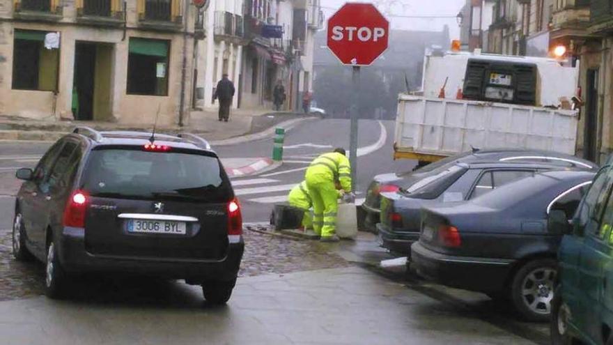 Operarios refuerzan la señal del Stop en la Plaza Mayor de Alcañices.