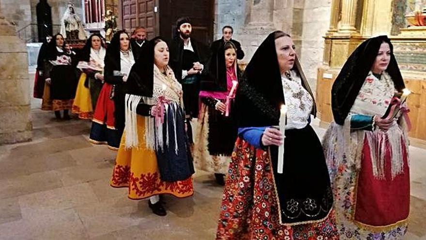 Participantes en el desfile procesional de Las Candelas, ataviados con trajes típicos, portan las velas encendidas y la imagen de la Virgen.