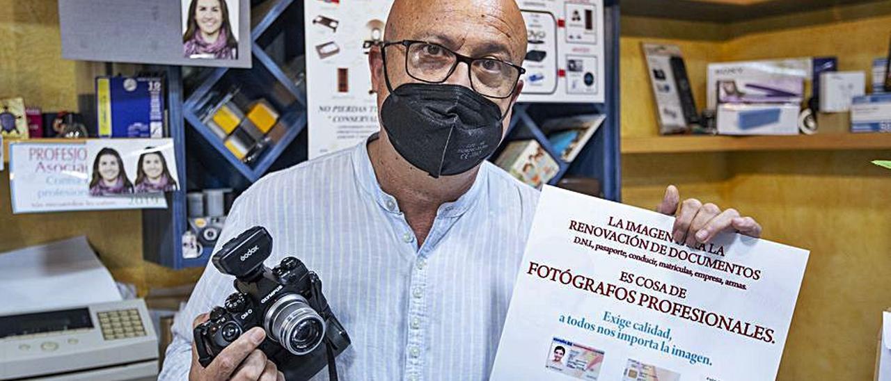 El fotógrafo Rafa Iniesta con un cartel reivindicativo. | ALEX DOMÍNGUEZ