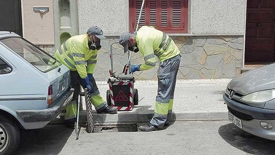 Dos técnicos revisan una alcantarilla en la que aplican el larvicida.