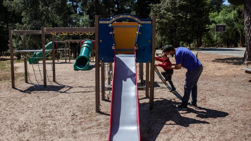 Un hombre juega con un niño en un parque.