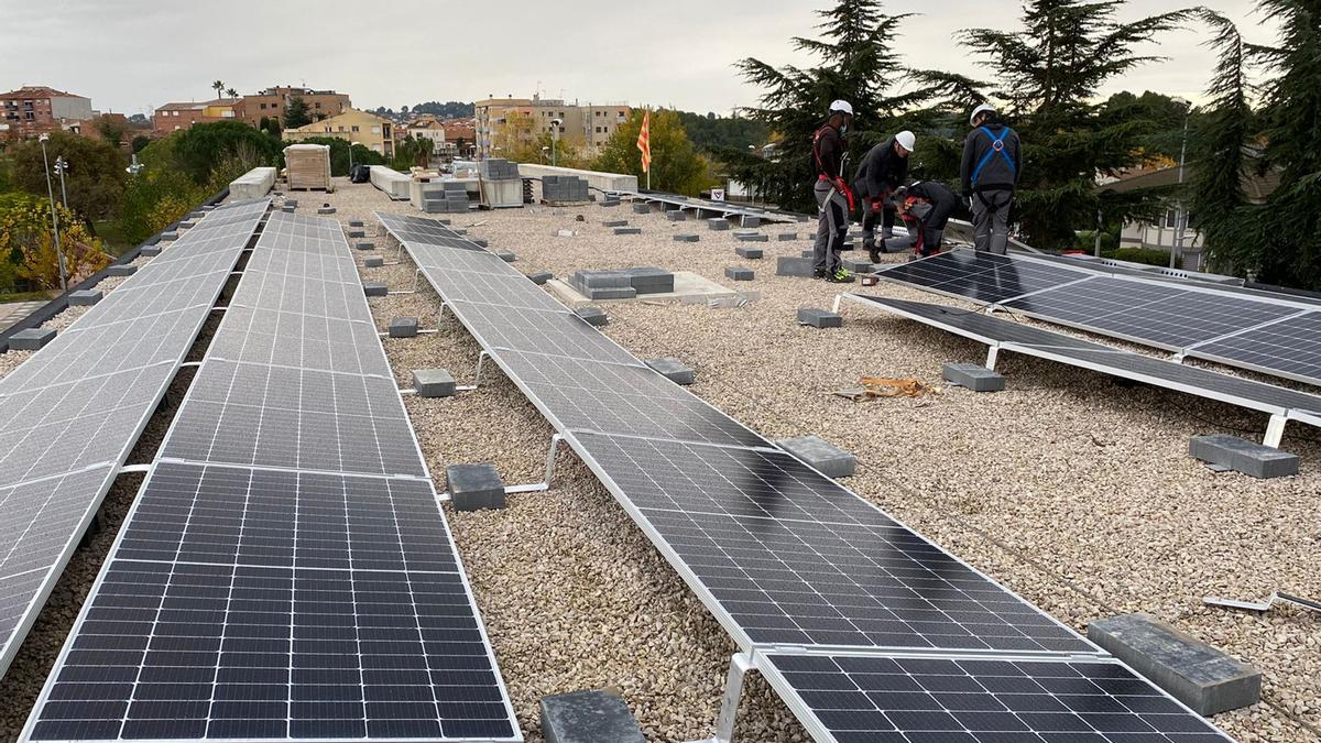 Operaris treballant en les plaques solars del CAP de Piera