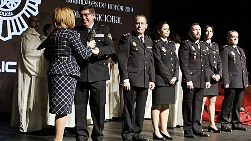 Ubaldo de la Torre recibe de manos de Isabel García el Barandales de Honor junto a varios compañeros de la Policía Nacional.