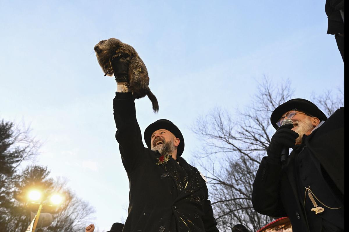 Groundhog Club handler A.J. Dereume holds Punxsutawney Phil, the weather prognosticating groundhog, during the 139th celebration of Groundhog Day on Gobbler's Knob in Punxsutawney, Pa., Sunday, Feb. 2, 2025. Phil's handlers said that the groundhog has forecast six more weeks of winter. (AP Photo/Barry Reeger)