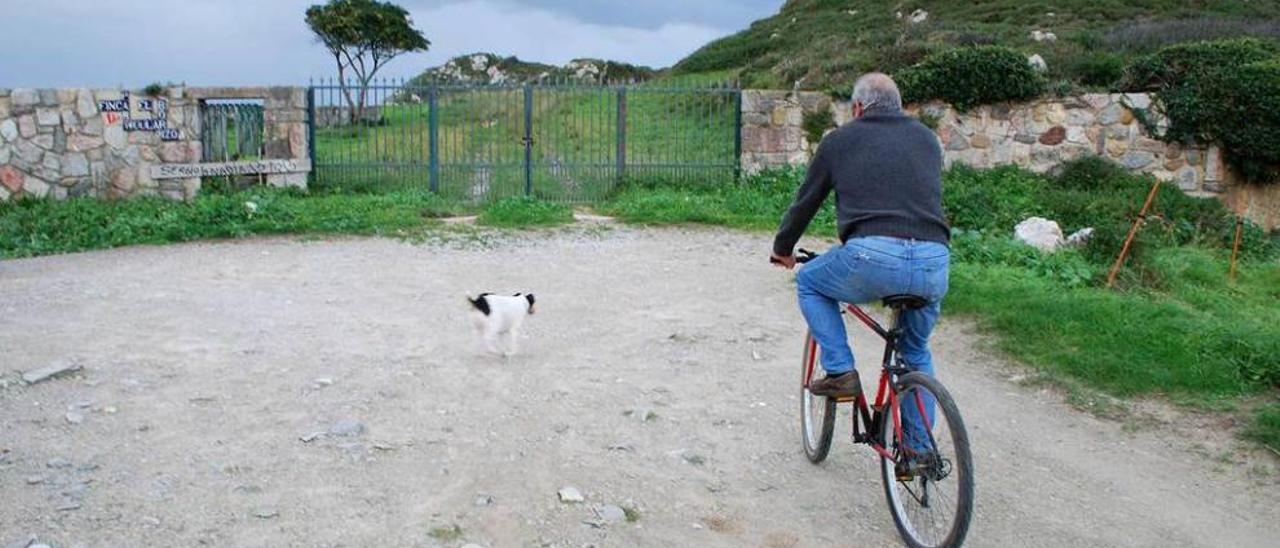 Un llanisco pasa en bicicleta junto a la entrada de Borizu.