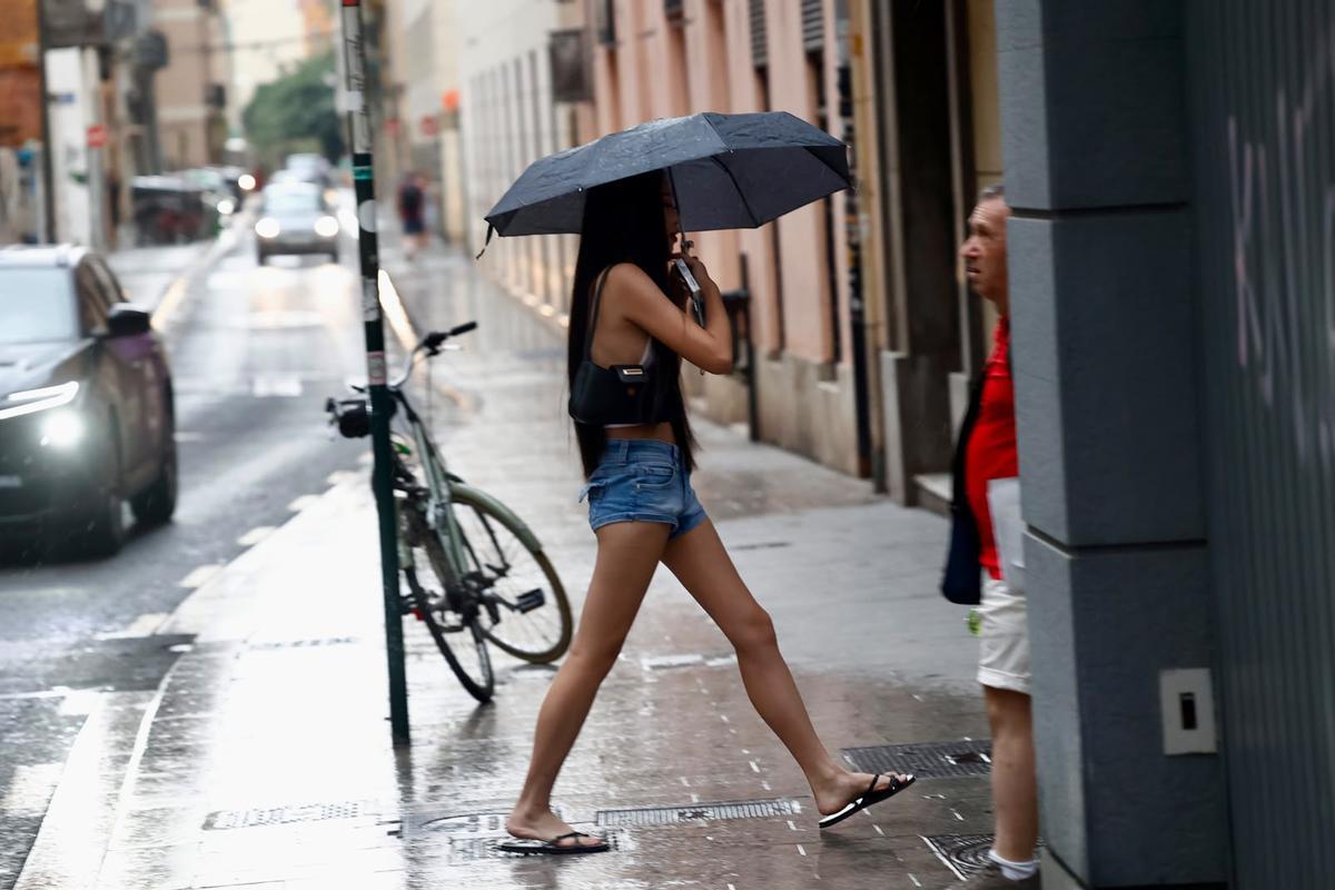 Una joven con paraguas esta tarde en València.