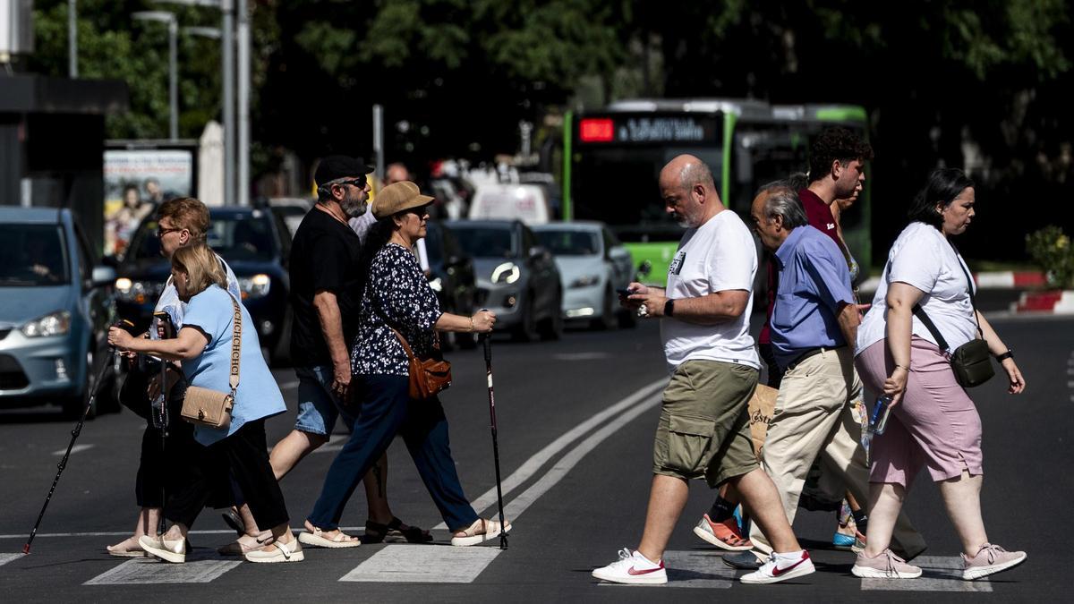 Personas atravesando un paso de peatones en Cáceres.