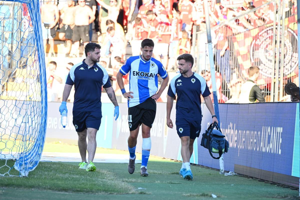 Unai Ropero abandona el campo acompañado por los fisios tras recibir un fuerte golpe en el Hércules-Nàstic.