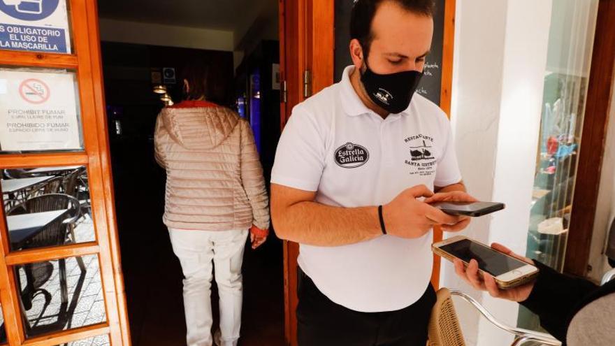 Un camarero del restaurante Santa Gertrudis lee el código QR con la aplicación del Govern.   |  J.A. RIERA