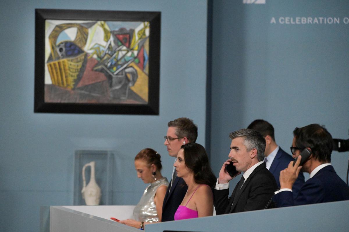 Miembros del personal de Sotheby's aceptan ofertas por teléfono mientras se subastan 11 cuadros y obras de Picasso en el Hotel Bellagio de Las Vegas.