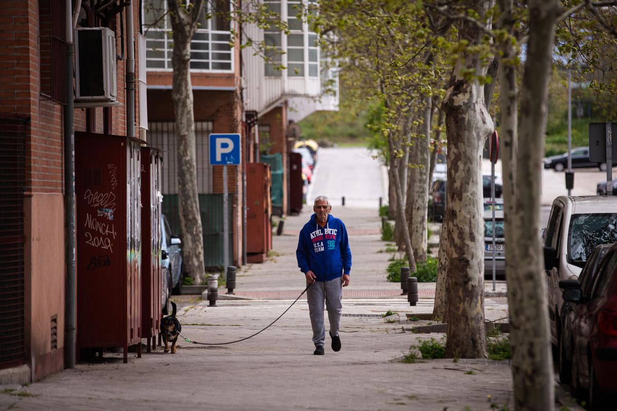 En vecino pasea a su perro cerca de la estación de Cercanías de Orcasitas.