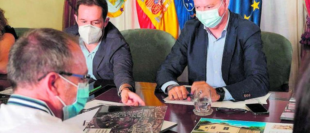 Sebastián Franquis (d) observa un mapa que el presidente del Cabildo de La Palma, Mariano Zapata, muestra a los asistentes a la reunión. | | ÁNGEL MEDINA (EFE)