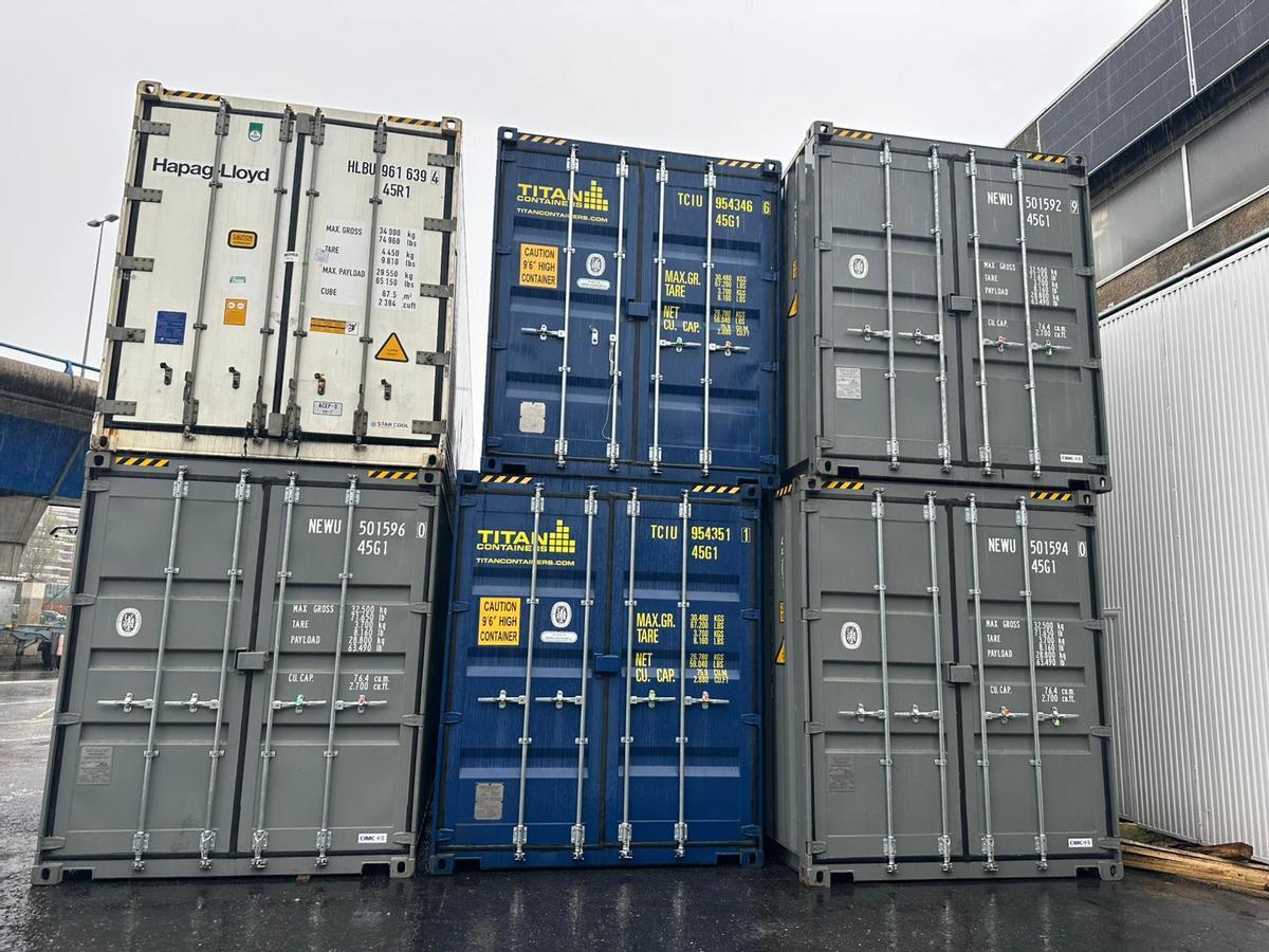 Los cinco depósitos (tres grises y dos azules) donde se han guardado los bolsos falsificados.