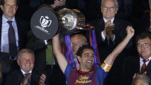 Barcelonas Xavi lifts up the Spanish Kings Cup trophy after winning their final soccer match against Athletic Bilbao in Madrid