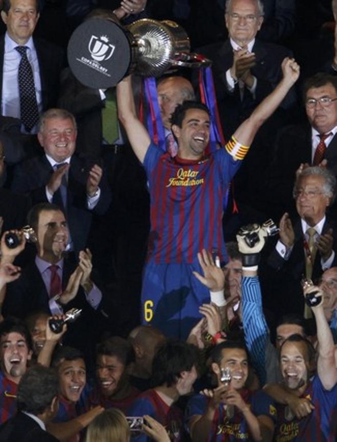 Barcelonas Xavi lifts up the Spanish Kings Cup trophy after winning their final soccer match against Athletic Bilbao in Madrid