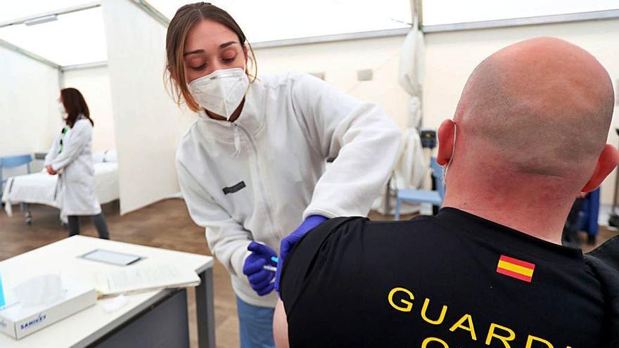 Una enfermera de La Fe vacuna a un guardia civil, ayer.  | F. CALABUIG