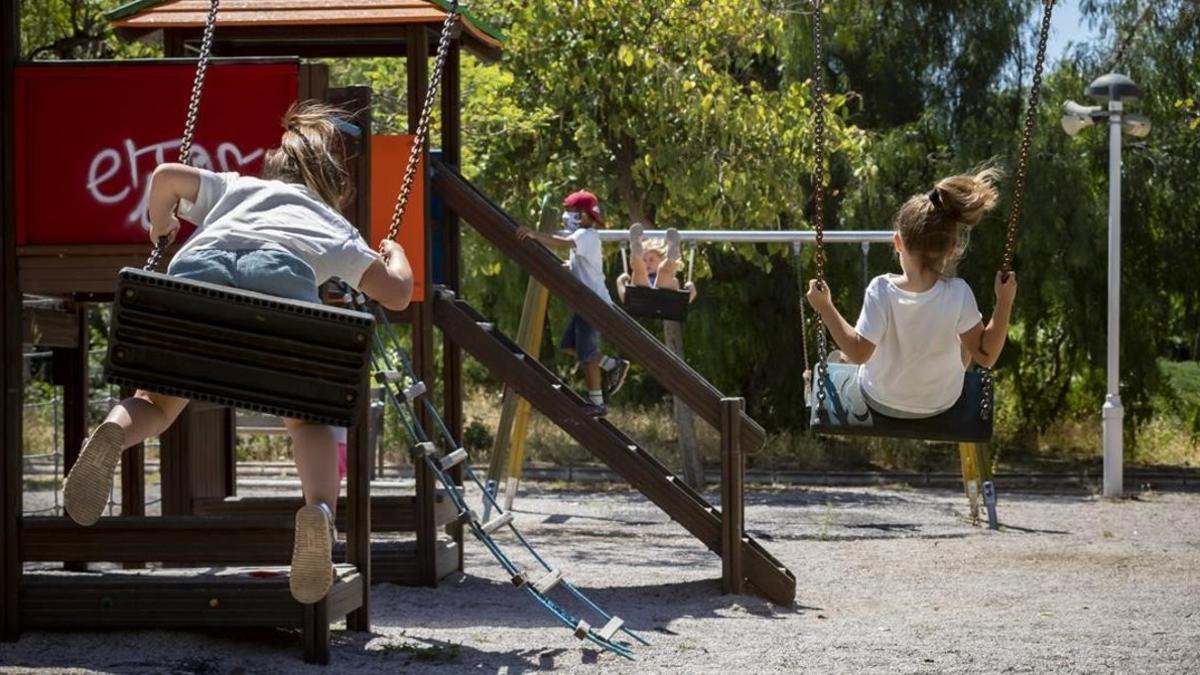 Varios niños juegan en un parque infantil, en València, donde ya no están precintados.