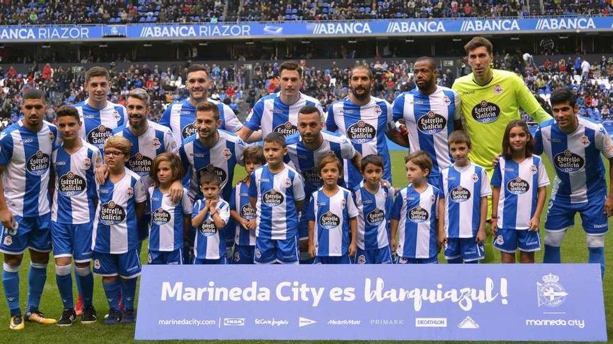 Los futbolistas que salieron inicialmente ante el Atlético posan con un grupo de niños antes de que empezase el partido.