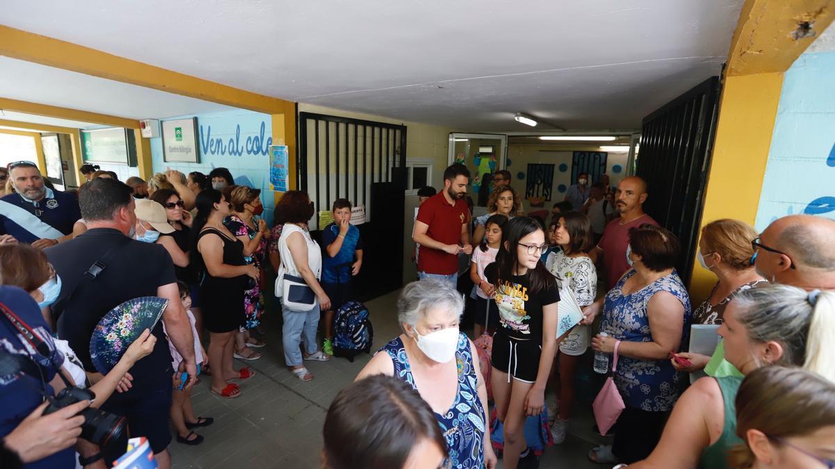 Una de las puertas del colegio, llena de padres, madres y abuelos esperando a los niños.