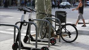 Patinetes de una de las empresas que desoyen la ordenanza municipal, aparcados en el paseo de Gràcia.  