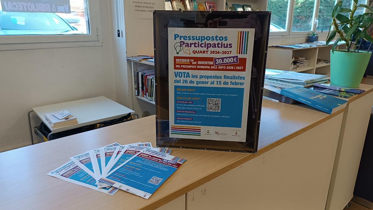 Cartell de la fase de votació i fotografia d’una de les urnes, ubicada a la Biblioteca Miquel Pairolí de Quart