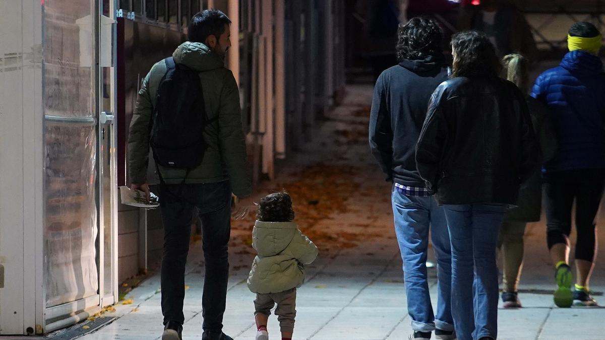 Unos padres pasean con su hija por una calle de Madrid.