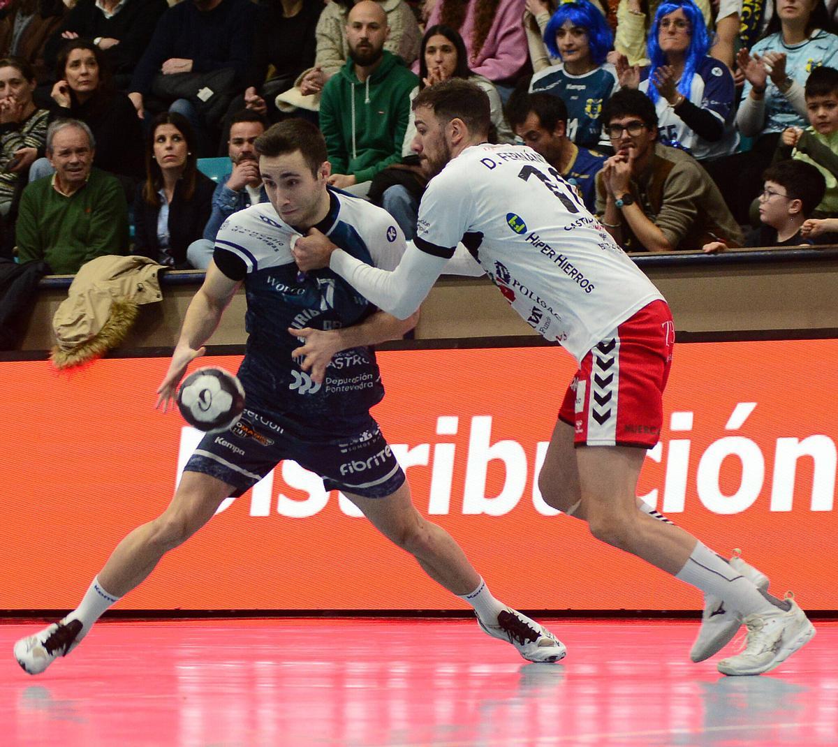 Manu Pérez es agarrado por David Fernández en el partido entre el Cangas y el Nava.