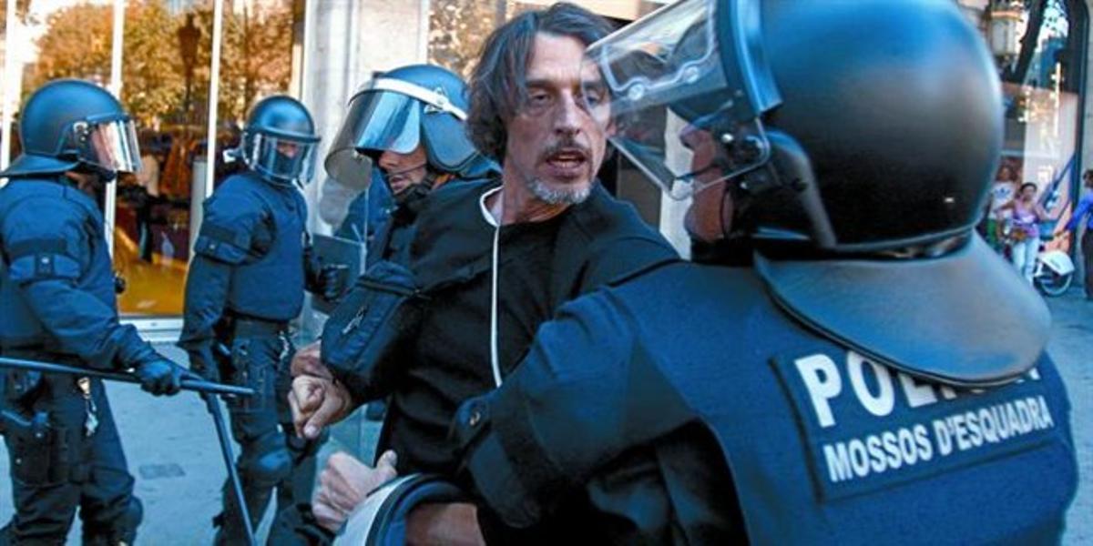 Pugna entre un agent de la policia i un manifestant, al passeig de Gràcia, dimecres passat, en el transcurs dels aldarulls posteriors al desallotjament de la seu del Banesto.