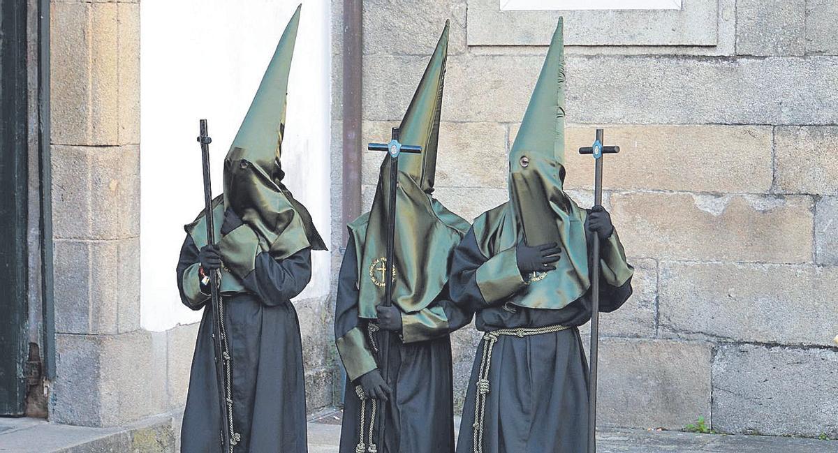 Tres cofrades en un momento del desfile durante la tarde de ayer
