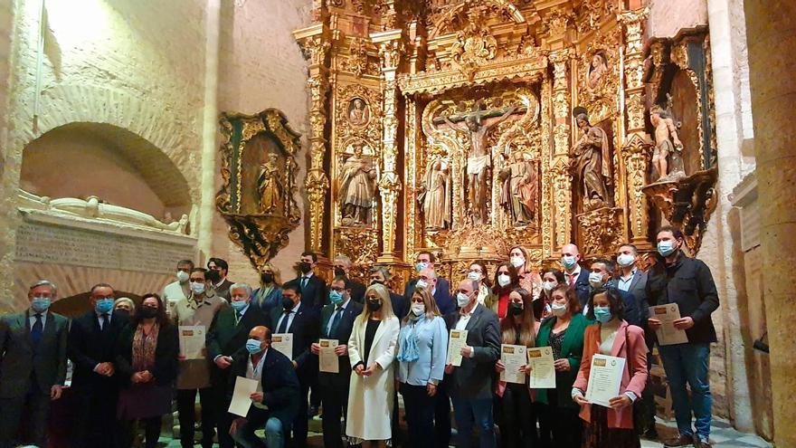 Foto de familia con los representantes municipales que recibieron el diploma en el monasterio de San Isidoro del Campo.