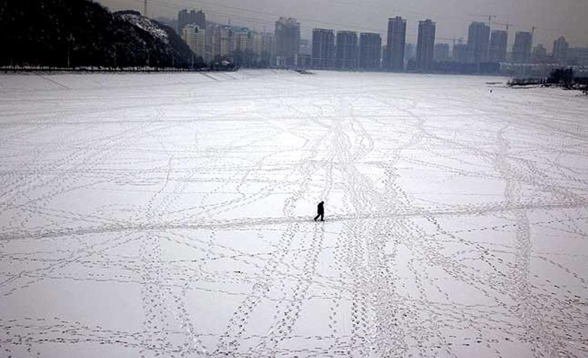 Un home camina per un riu congelat a Benxi, província de Liaoning, al nord-est de la Xina.