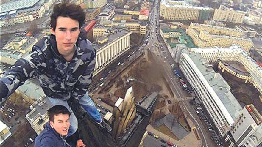 El ruso Kirill Oreshkin, pionero de los selfis de alto riesgo, se saca uno con otro joven en lo alto de un edificio.