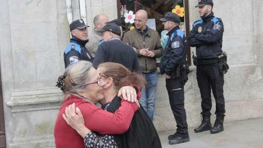 Dos mujeres mayores se abrazan al ver la retirada. // S.A.